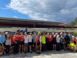 Group photo of rowing team in front of boats at the Occoquan