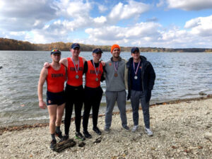 5 4th-year varsity members smiling after winning medals at a regatta